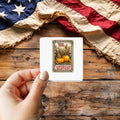 American Harvest sticker held over a vintage American flag on rustic wood, patriotic Thanksgiving gift
