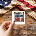 American Veteran Vintage Tin Sign sticker held over a vintage American flag on rustic wood, Veterans Day gift