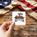 Bless This Table sticker held over a vintage American flag on rustic wood, patriotic Thanksgiving gift