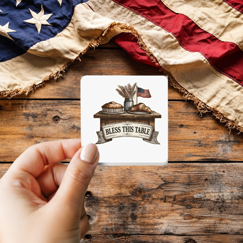 Bless This Table sticker held over a vintage American flag on rustic wood, patriotic Thanksgiving gift