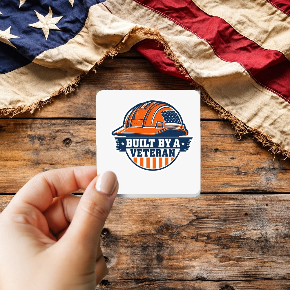 Built by a Veteran sticker held over a vintage American flag on rustic wood, Veterans Day gift