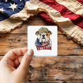 Bulldog Veteran Cartoon Style sticker held over a vintage American flag on rustic wood, Veterans Day gift