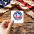 Cold War Veteran sticker held over a vintage American flag on rustic wood, Veterans Day gift