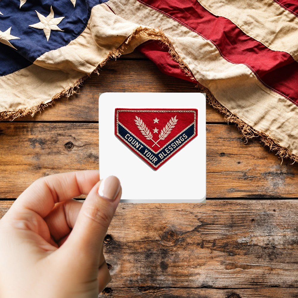 Count Your Blessings sticker held over a vintage American flag on rustic wood, patriotic Thanksgiving gift