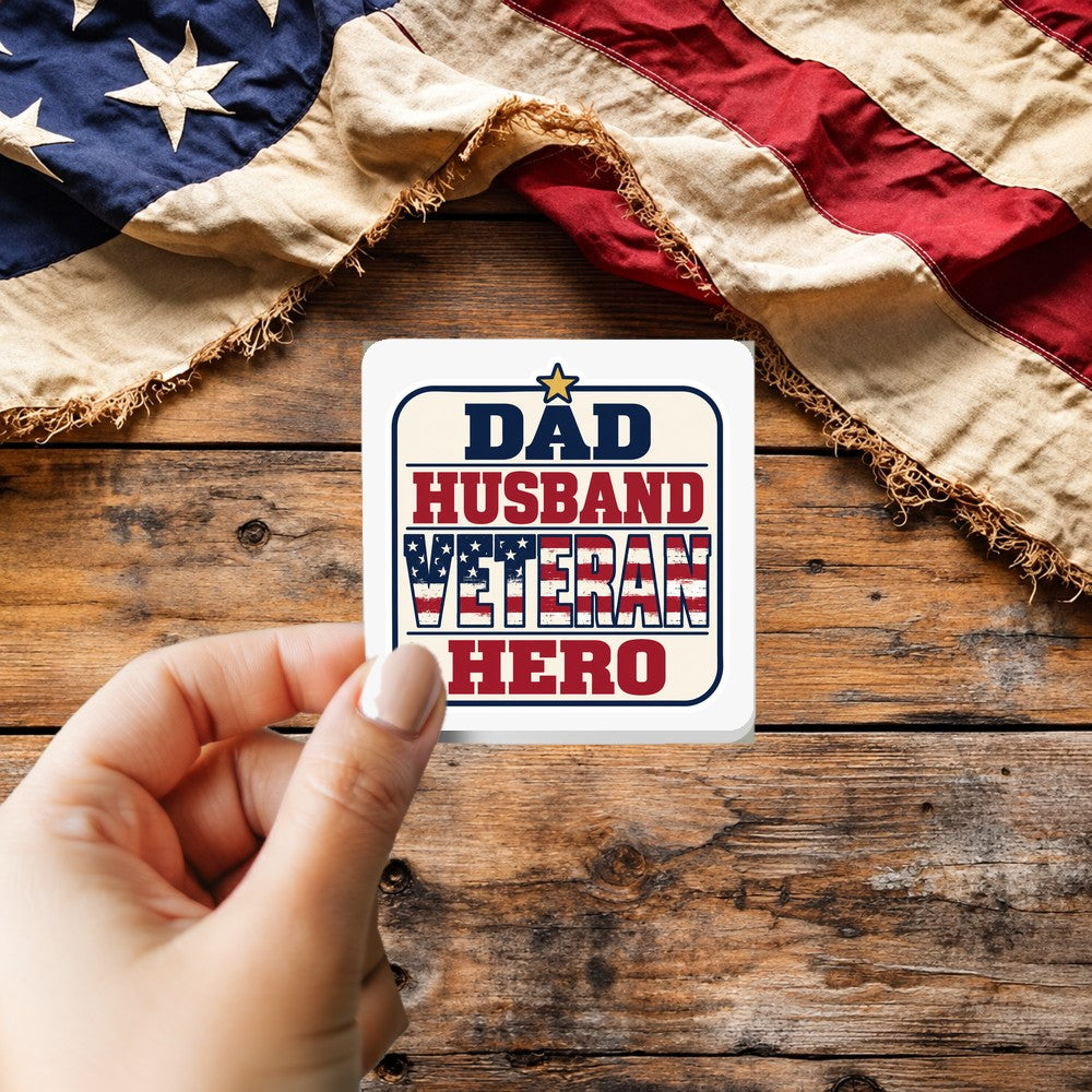 Dad Husband Veteran Hero sticker held over a vintage American flag on rustic wood, Veterans Day gift