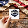 Honorably Discharged sticker held over a vintage American flag on rustic wood, Veterans Day gift