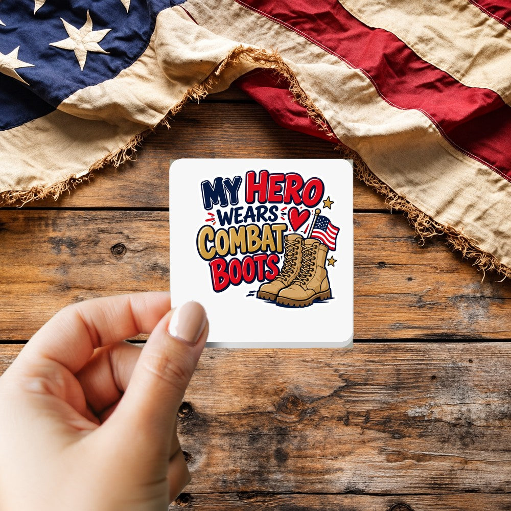 My Hero Wears Combat Boots sticker held over a vintage American flag on rustic wood, Veterans Day gift