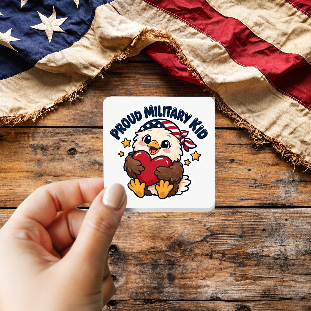 Proud Military Kid sticker held over a vintage American flag on rustic wood, Veterans Day gift