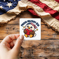Proud Military Kid sticker held over a vintage American flag on rustic wood, Veterans Day gift