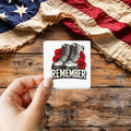 Remember Combat Boots Woodcut sticker held over a vintage American flag on rustic wood, Veterans Day gift