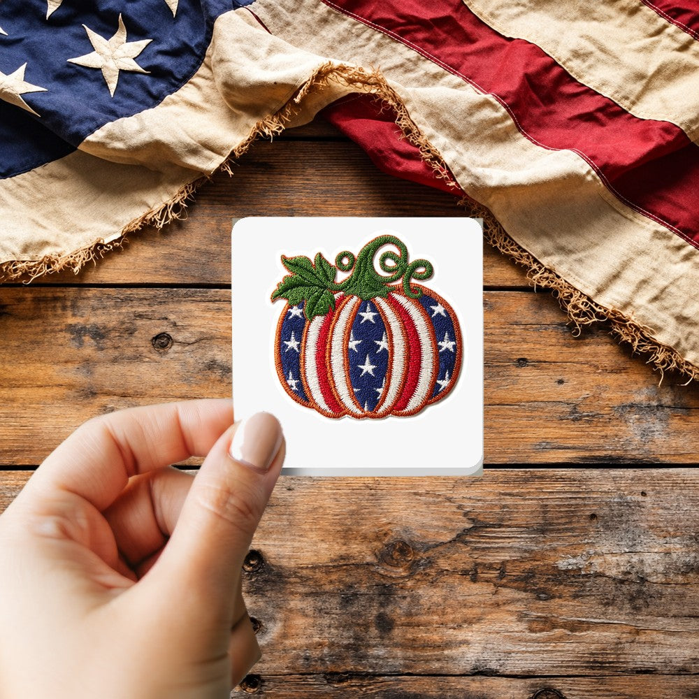 Stars and Stripes Pumpkin sticker held over a vintage American flag on rustic wood, patriotic Thanksgiving gift