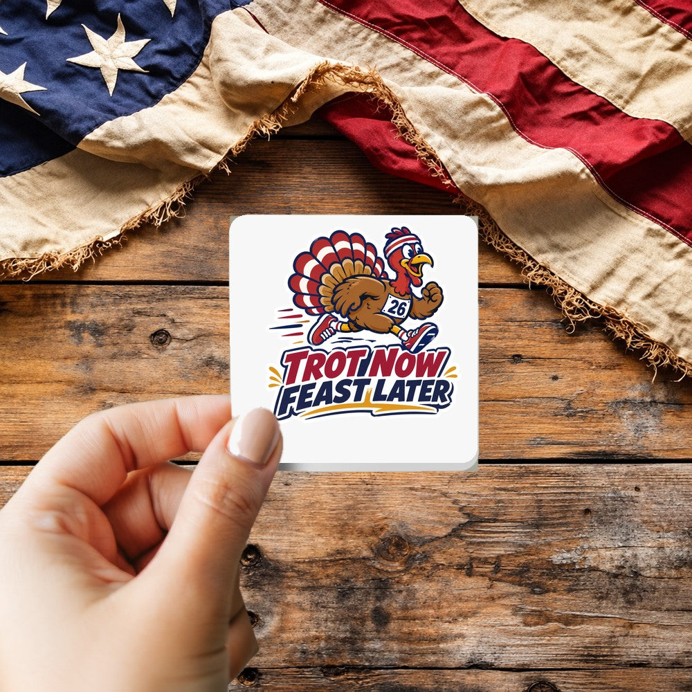 Trot Now Feast Later sticker held over a vintage American flag on rustic wood, patriotic Thanksgiving gift