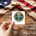 Veteran Merit Badge Style sticker held over a vintage American flag on rustic wood, Veterans Day gift