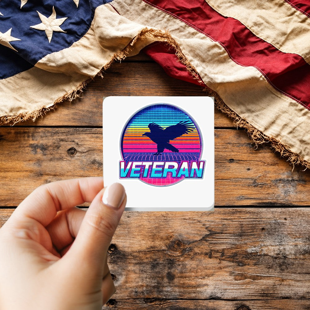 Veteran Retro 80s Synthwave sticker held over a vintage American flag on rustic wood, Veterans Day gift